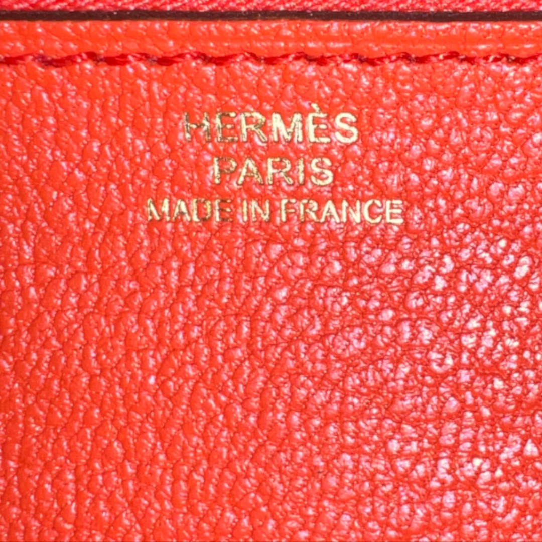 HERMÈS BRIEFTASCHE KELLY CLASSIQUE AUS VEAU GHILLIES SWIFT IN PRUNE/POPPY ORANGE MIT GHW